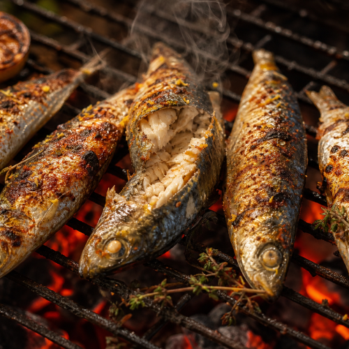 Sardines entières grillées sur une grille de barbecue, peau dorée et parsemée d'épices, avec des tranches de citron